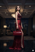 Alluring elegant woman carrying the deep red patent leather Love Bag in a luxury setting