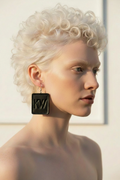 Elegant Spanish albino woman wearing KW signature leather large dangle earrings