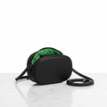 The Simple Crossbody black oval dome bag with emerald green KW lining on marble surface